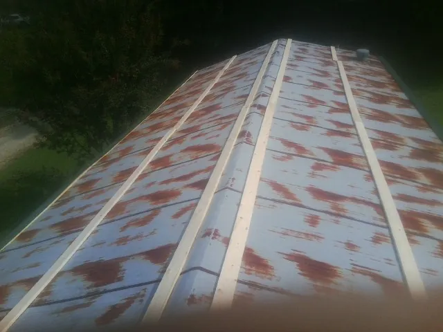 Rusted metal roof panels with new wood purlins before replacement — Storm Damage Roof Repair in Rineyville by Roofing Brothers