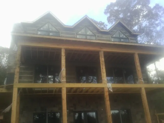 Dormers and porch framing on a large log home under construction — Roof Coating work by our crew in Rineyville
