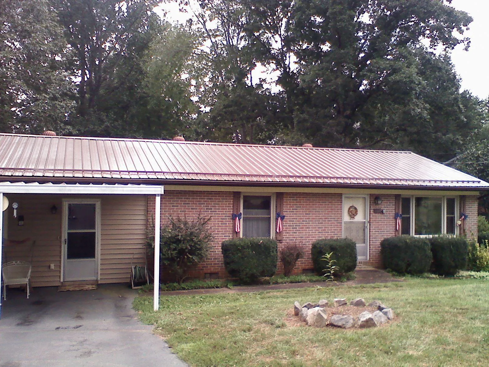 Bronze metal roof and carport on a brick ranch home — Roof Repair work by our crew in Rineyville